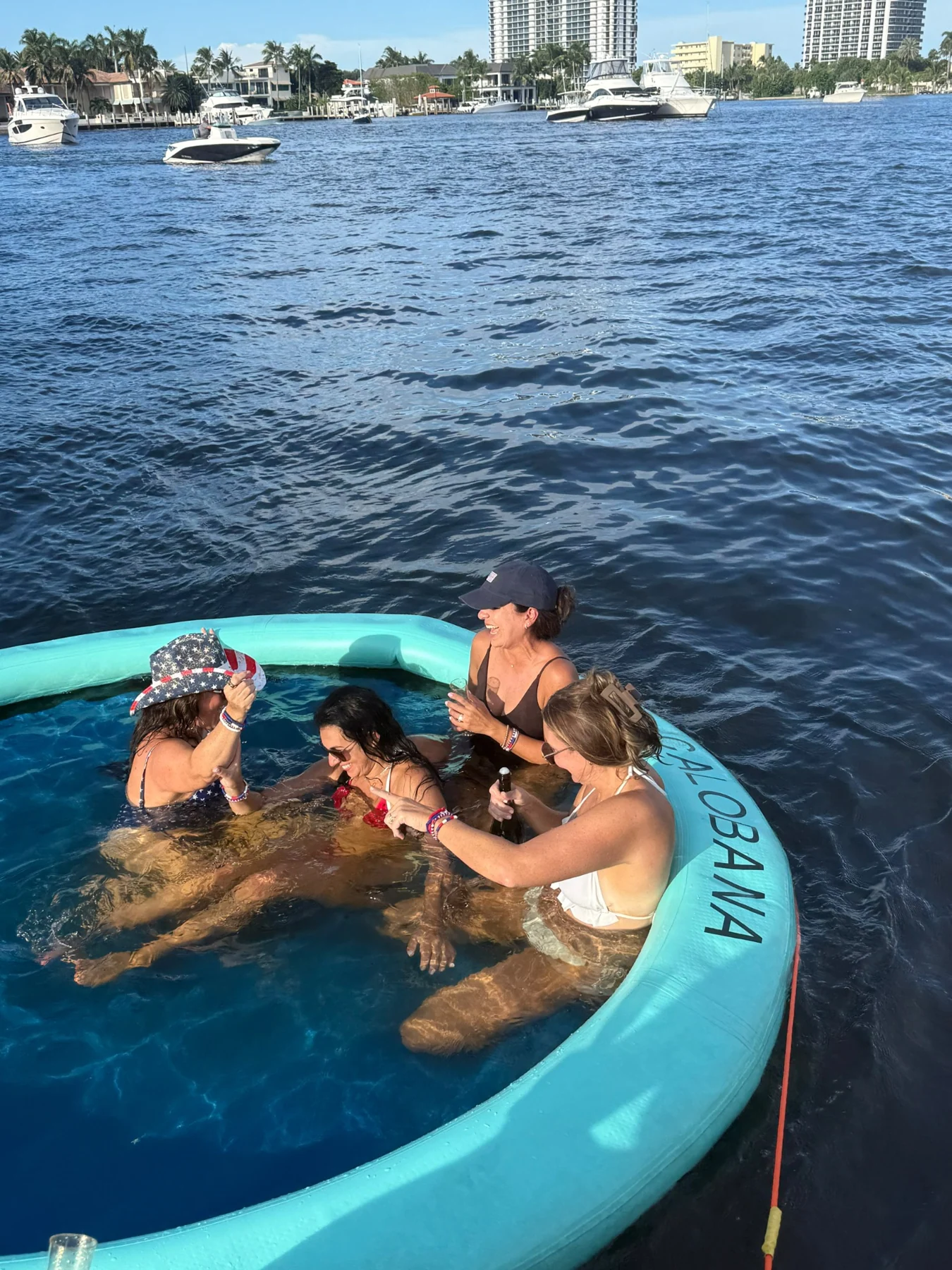 Friends relaxing in a circular float beside the yacht