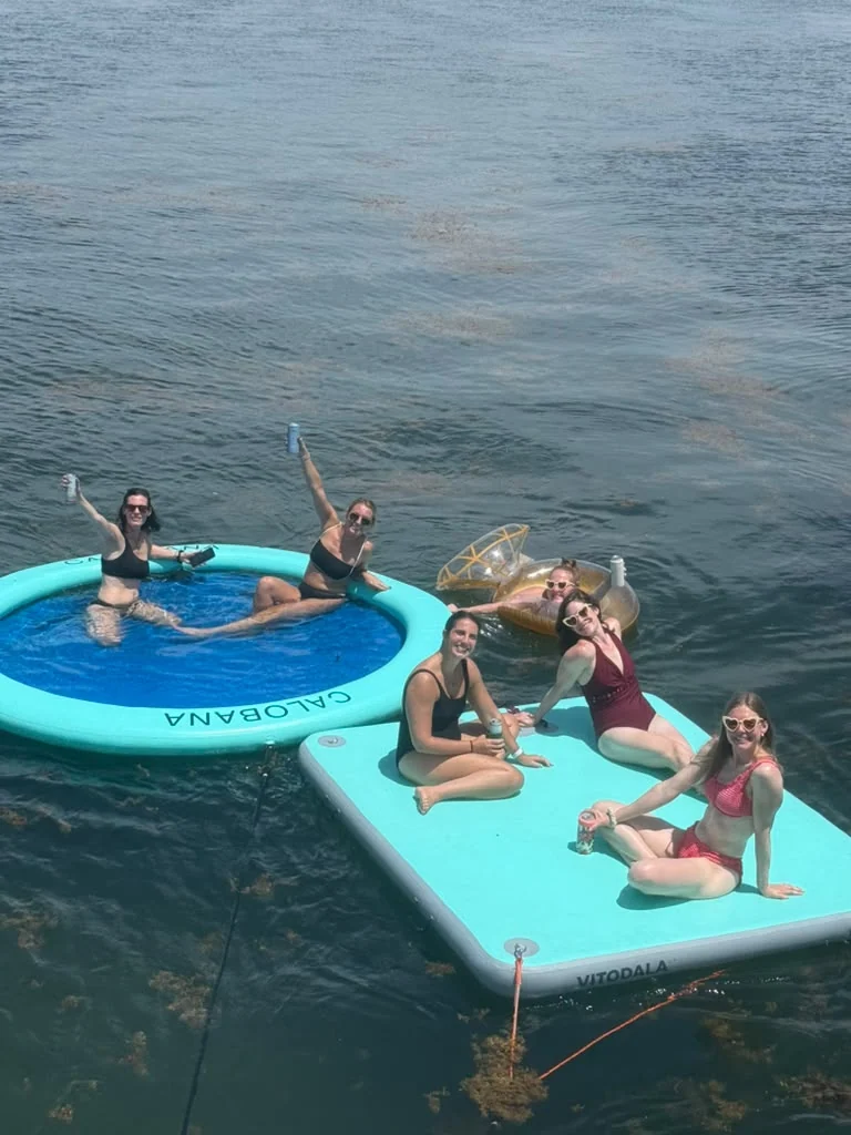 Guests relaxing on a floating mat beside a circular float